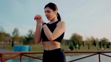 Gün batımında gölün yanındaki parkta spor yapan genç atletik kadın. Hayat konsepti.