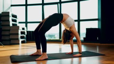 Genç atletik kadın spor salonunda yoga yapıyor. Yoga ve spor. Sağlıklı yaşam tarzı konsepti 4K.