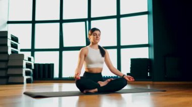 Genç atletik kadın spor salonunda yoga yapıyor. Yoga ve spor. Sağlıklı yaşam tarzı konsepti 4K.