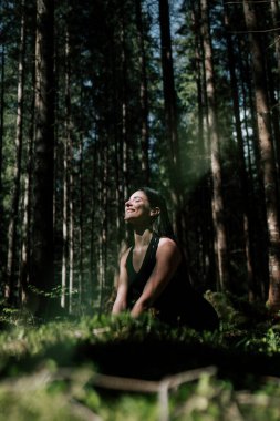 Genç bir kadın ormanda yoga yapıyor ve meditasyon yapıyor. Yoga ve meditasyon konsepti. Yoga asanas. 