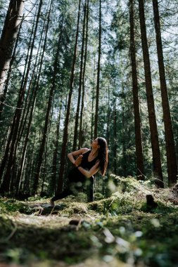 Genç bir kadın ormanda yoga yapıyor ve meditasyon yapıyor. Yoga ve meditasyon konsepti. Yoga asanas. 