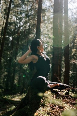 Genç bir kadın ormanda yoga yapıyor ve meditasyon yapıyor. Yoga ve meditasyon konsepti. Yoga asanas. 