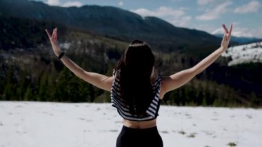 Karlı dağların tepesinde meditasyon yapan genç bir kadın. Yoga ve meditasyon konsepti. Yoga asanas 4k.