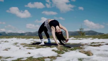 Karlı dağların tepesinde meditasyon yapan genç bir kadın. Yoga ve meditasyon konsepti. Yoga asanas 4k.
