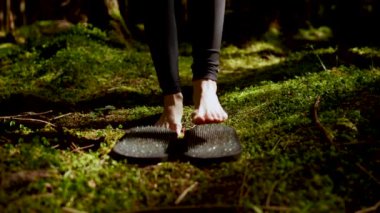 Peri ormanında çivilerle tahta üzerinde duran bir kadın. Ayaklar güvertede Sadhu. Yoga ve meditasyon konsepti