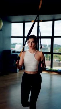 Trx Sistemle egzersiz yapan güzel bir kadın. Döngülerle spor yapıyor. Sağlıklı yaşam tarzı sporu hariç.