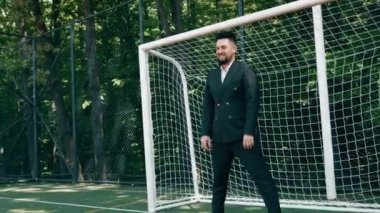 Klasik takım elbiseli bir grup arkadaş futbol oynarken eğleniyorlar. Futbol konsepti