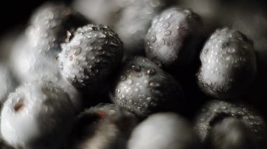 Yabanmersini siyah arka planda bir tabakta döner. Böğürtlen kavramı 4k