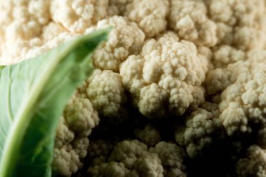 Siyah arka planda bir tabakta çiğ karnabahar. Sebze konsepti.