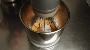 Tavuk yumurtaları karıştırıcıda şekerle karıştırılır. Şekerleme üretimi. Pasta ve hamur işi kavramı