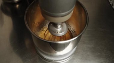 Tavuk yumurtaları karıştırıcıda şekerle karıştırılır. Şekerleme üretimi. Pasta ve hamur işi kavramı