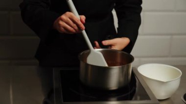 Şekerleme makinesi karamel hazırlamak için tavada şeker eritiyor. Evde karamel yapıyorum. Şekerleme ve kek kavramı