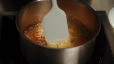 Şekerleme makinesi karamel hazırlamak için tavada şeker eritiyor. Evde karamel yapıyorum. Şekerleme ve kek kavramı