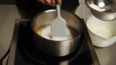 Şekerleme makinesi karamel hazırlamak için tavada şeker eritiyor. Evde karamel yapıyorum. Şekerleme ve kek kavramı