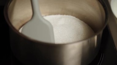Şekerleme makinesi karamel hazırlamak için tavada şeker eritiyor. Evde karamel yapıyorum. Şekerleme ve kek kavramı