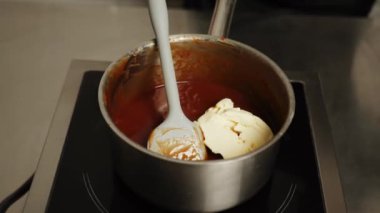 Şekerleme makinesi karamel hazırlamak için tavada şeker eritiyor. Evde karamel yapıyorum. Şekerleme ve kek kavramı