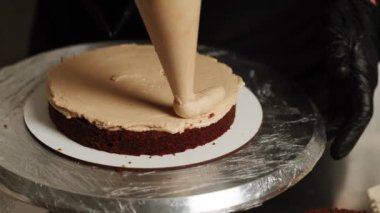 Pasta şefi kahveli kek hazırlıyor. Pastayı hazırlama süreci. Pasta şefi pastaya krema ve karamel sürüyor. Pastayı monte ediyorum. Hamur işi kavramı