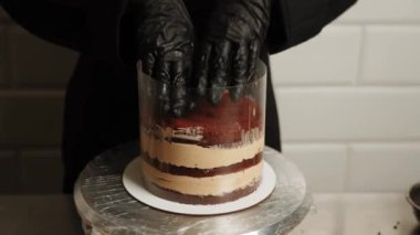 Pasta şefi kahveli kek hazırlıyor. Pastayı hazırlama süreci. Pasta şefi pastaya krema ve karamel sürüyor. Pastayı monte ediyorum. Hamur işi kavramı