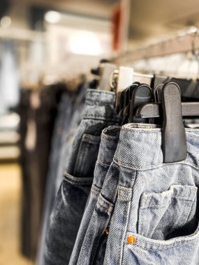 Kıyafet mağazasının genel manzarası. Giysileri, pantolonları, ayakkabıları ve şapkaları olan raflar. Alışveriş konsepti