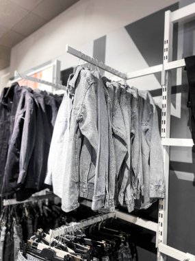 Kıyafet mağazasının genel manzarası. Giysileri, pantolonları, ayakkabıları ve şapkaları olan raflar. Alışveriş konsepti