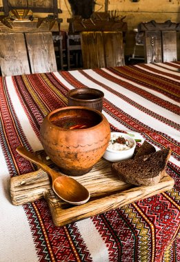 Ekmek ve domuz yağıyla işlenmiş borç. Masanın üzerindeki sürahide işlenmiş bir havlu. Ulusal Ukrayna yemeği. Etli pancar çorbası kavramı