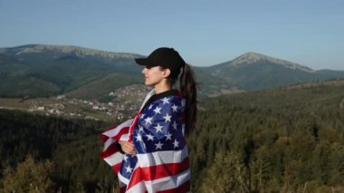 Genç bir kadın bir Amerikan bayrağını dağın tepesinde tutuyor. Amerikan bayrağı taşıyan bir kadın. Özgürlük ve demokrasi kavramı. ABD 'de seçimler