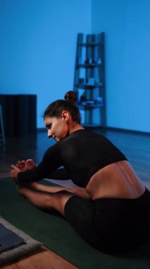 Bilgisayarla yoga yapan genç bir kadın..