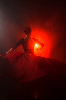 Kırmızı etekli bir kadının silueti neon ışıkta Latince dans ediyor. Dans konsepti. Bachata, Latino. Rumba. Samba.