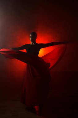 Kırmızı etekli bir kadının silueti neon ışıkta Latince dans ediyor. Dans konsepti. Bachata, Latino. Rumba. Samba.