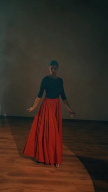 Kırmızı elbiseli bir kadın stüdyoda dumanların içinde ateşli bir İspanyol dansı yapıyor. Samba, Rumba. Dans konsepti. Dikey video