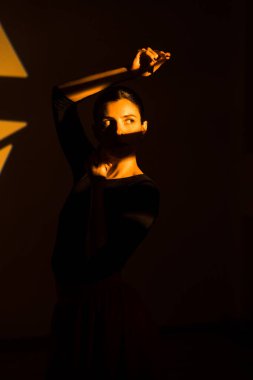 Dansçı bir kadın arka planda gobo maskelerin aydınlatılmasına karşı poz veriyor. Bir kadın İspanyol dansı yapıyor. Koreografi ve dans konsepti