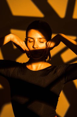 Dansçı bir kadın arka planda gobo maskelerin aydınlatılmasına karşı poz veriyor. Bir kadın İspanyol dansı yapıyor. Koreografi ve dans konsepti