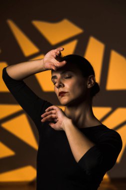 Dansçı bir kadın arka planda gobo maskelerin aydınlatılmasına karşı poz veriyor. Bir kadın İspanyol dansı yapıyor. Koreografi ve dans konsepti