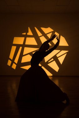 Dansçı bir kadın arka planda gobo maskelerin aydınlatılmasına karşı poz veriyor. Bir kadın İspanyol dansı yapıyor. Koreografi ve dans konsepti