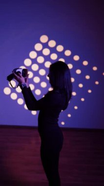 Bir kadın sanal gerçeklik dünyasının tadını VR gözlükleriyle çıkarır. Sanal gerçeklik kulaklığı. Yapay zeka. VR gözlük konsepti. Dikey video 4k