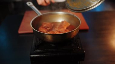 Şef soslu dana pirzola hazırlar. Şef etin üzerine baharat ve otlar serpiyor. Et kaburgası kavramı.