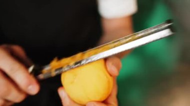 Bir şekerci limon, limon ve portakal kabuklarını rendeliyor. Turunçgil lezzeti üretimi. Şekerleme ürünleri kavramı