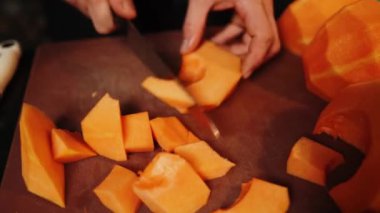 Aşçı olgun bir portakal kabağını keser. Balkabağı tabağı. Sonbahar yemekleri konsepti 4k