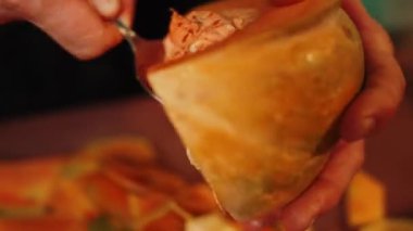 Aşçı olgun bir portakal kabağını keser. Balkabağı tabağı. Sonbahar yemekleri konsepti 4k