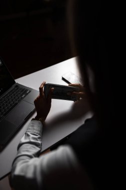 Dizüstü bilgisayarla uğraşırken elinde bir yığın para tutan bir kadın. Muhasebeci parayla çalışır. Bankada çalışma kavramı. Kredi ve krediler. Para saymak. İnternetten kazançlar.