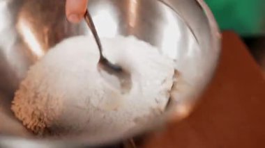 Şef hamuru demir bir tabakta yoğurur. Hamur yoğuran eller. Ekmek ürünlerinin üretimi için kavram