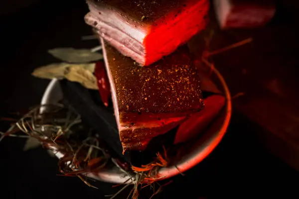 Siyah arka planda yanan bir tabakta yanmış domuz yağı. Ukrayna mutfağı konsepti. Haşlanmış domuz yağı. Izgara domuz yağı.