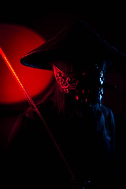 Maskeli ve geleneksel Japon başlıklı bir kadın Samuray kılıcıyla poz veriyor. Japon kültürü kavramı. Samuray. Katana.