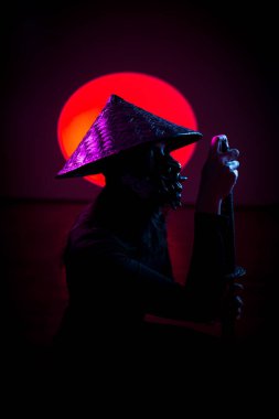 Maskeli ve geleneksel Japon başlıklı bir kadın Samuray kılıcıyla poz veriyor. Japon kültürü kavramı. Samuray. Katana.