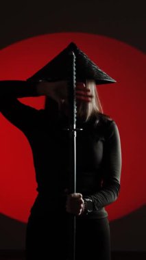 Maskeli ve geleneksel Japon başlıklı bir kadın Samuray kılıcıyla poz veriyor. Japon kültürü kavramı. Samuray. Katana.