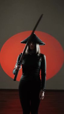 Maskeli ve geleneksel Japon başlıklı bir kadın Samuray kılıcıyla poz veriyor. Japon kültürü kavramı. Samuray. Katana.