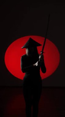 Maskeli ve geleneksel Japon başlıklı bir kadın Samuray kılıcıyla poz veriyor. Japon kültürü kavramı. Samuray. Katana.