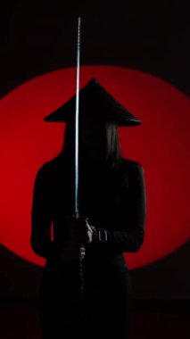Maskeli ve geleneksel Japon başlıklı bir kadın Samuray kılıcıyla poz veriyor. Japon kültürü kavramı. Samuray. Katana.