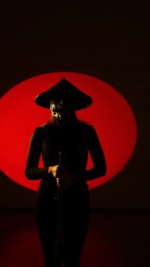 Maskeli ve geleneksel Japon başlıklı bir kadın Samuray kılıcıyla poz veriyor. Japon kültürü kavramı. Samuray. Katana.