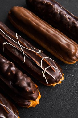 Siyah arka planda çikolata tüpleri. Farklı renkte tatlı dolgulu tüpler. Tatlılar konsepti